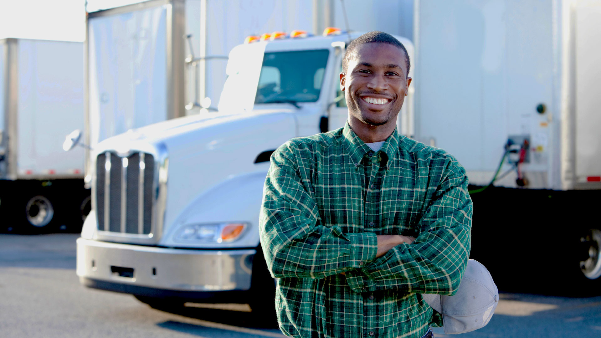 male-truck-driver-white-truck-smiling-1_adj_1920x1080